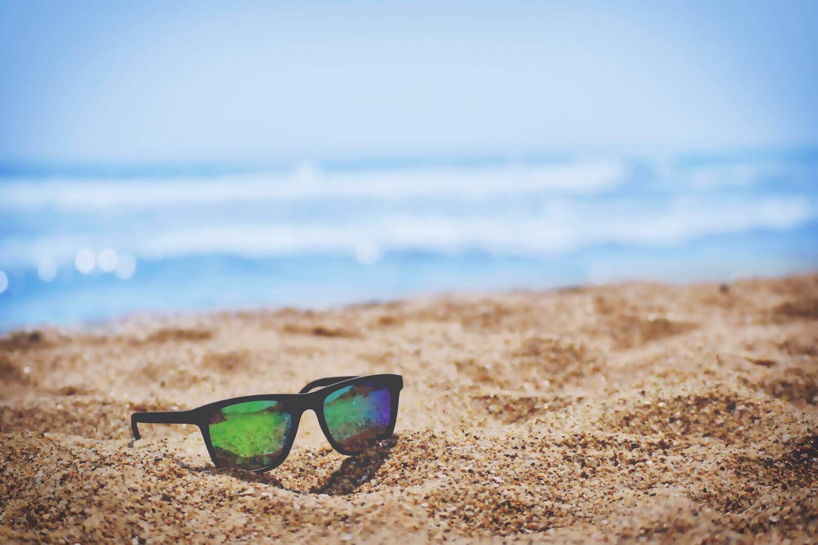okulary przeciwsłoneczne leżące na plaży