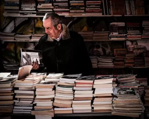 mężczyzna przegląda książkę na stoisku księgarskim