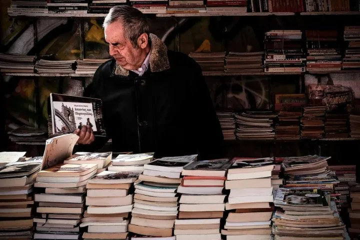 mężczyzna przegląda książkę na stoisku księgarskim