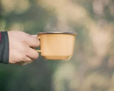 dłoń trzymają kubek kawy