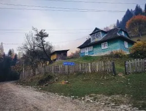 drewniany dom otoczony płotem na ukraińskiej wsi