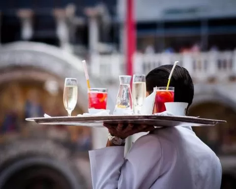 mężczyzna niosący tacę z napojami alkoholowymi